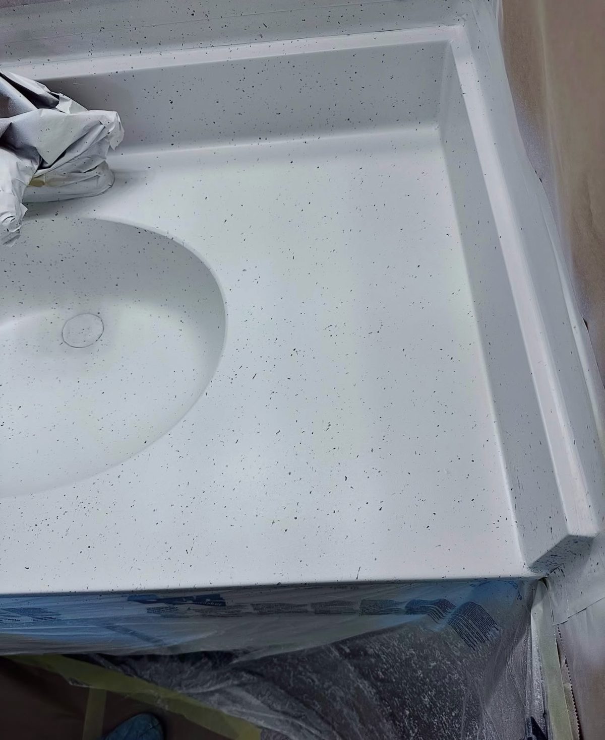 Bathroom vanity top refinished with a clean white speckled stone finish
